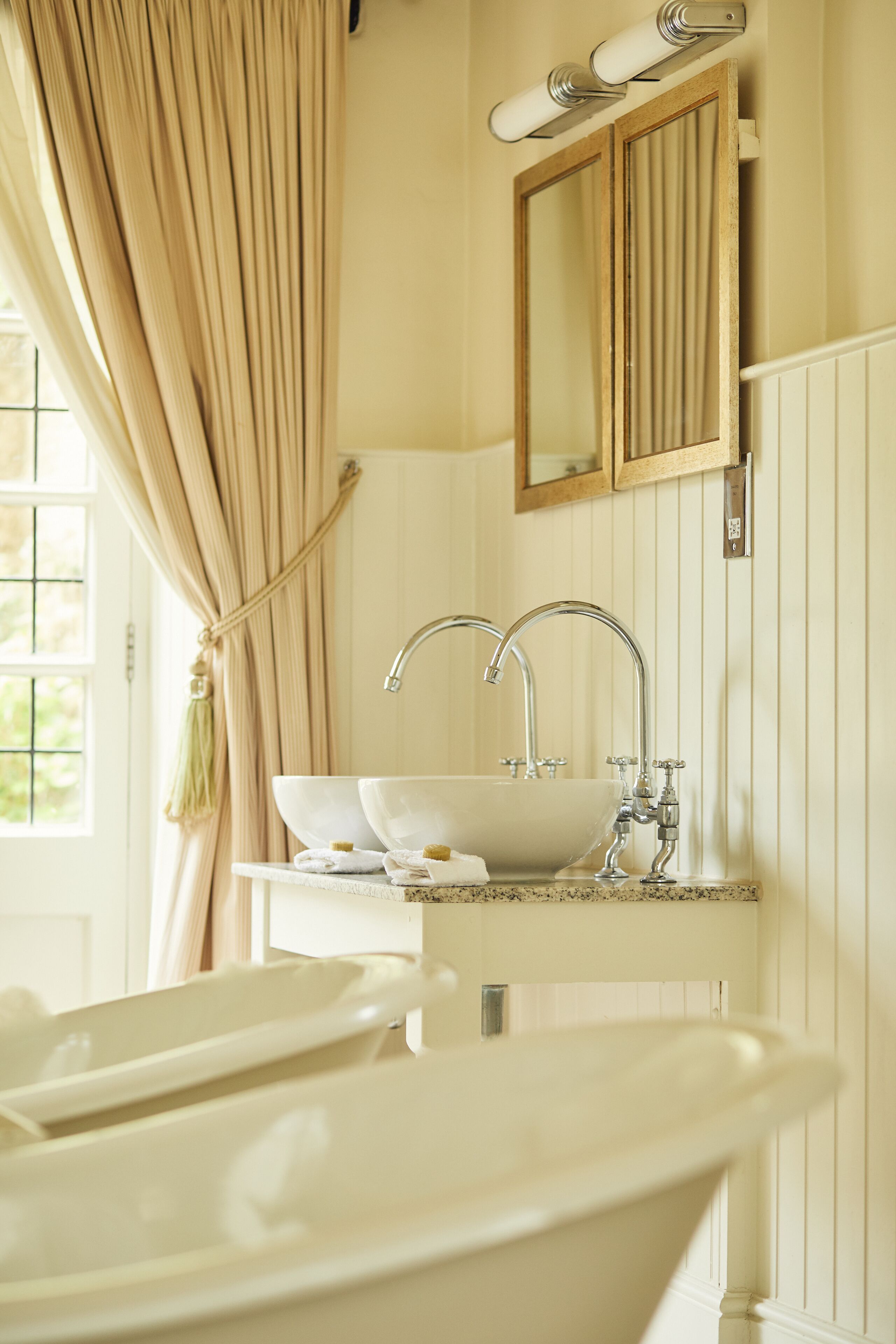 A bathroom with a bathtub, a sink, and a mirror.