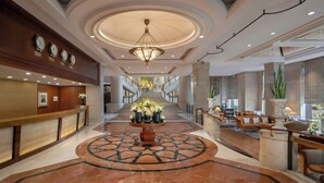 A spacious lobby with a central fountain, a reception desk, and a staircase leading to upper floors. - Sheraton New Delhi Hotel (New Delhi)