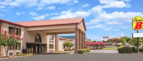 Un hotel Super 8 con techo rojo, una entrada cubierta y un cartel que indica que es un hotel Gateway.