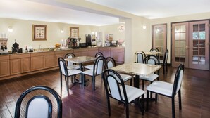 A spacious kitchen with wooden cabinets, a dining area with a large table and chairs, and a refrigerator.