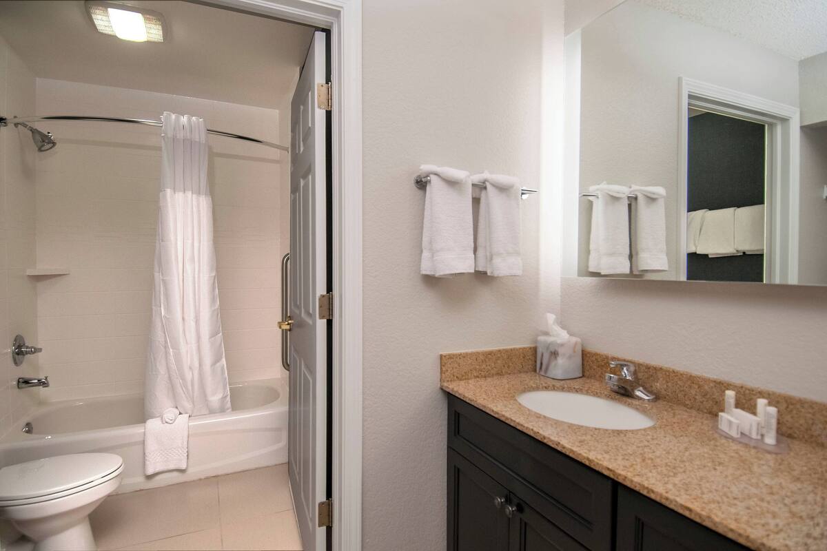 A bathroom with a bathtub, toilet, sink, and towel rack.