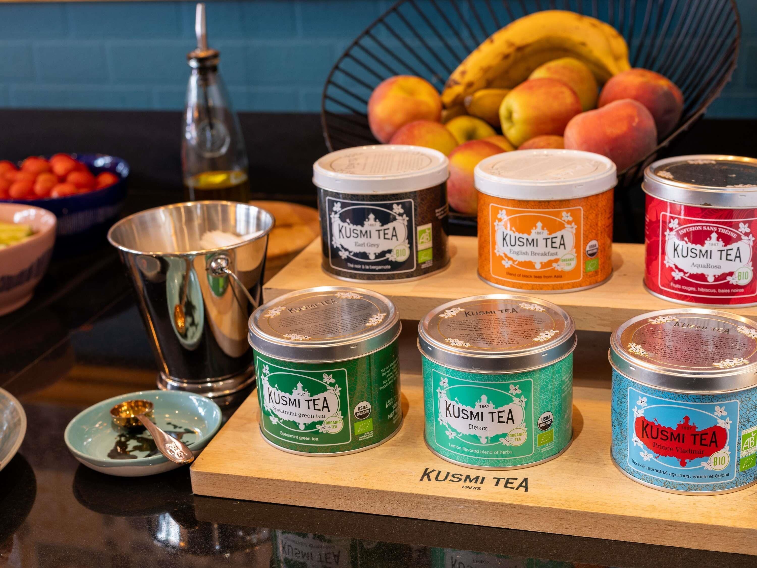 Varias latas de té Kusmi sobre una tabla de madera.