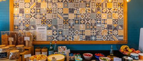 Un bufé con diferentes opciones de comida, un letrero que dice 'pommey' y una pared con azulejos decorados.