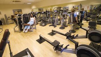 Un gimnasio con diversas máquinas de ejercicio, incluyendo cintas de correr y máquinas de pesas.