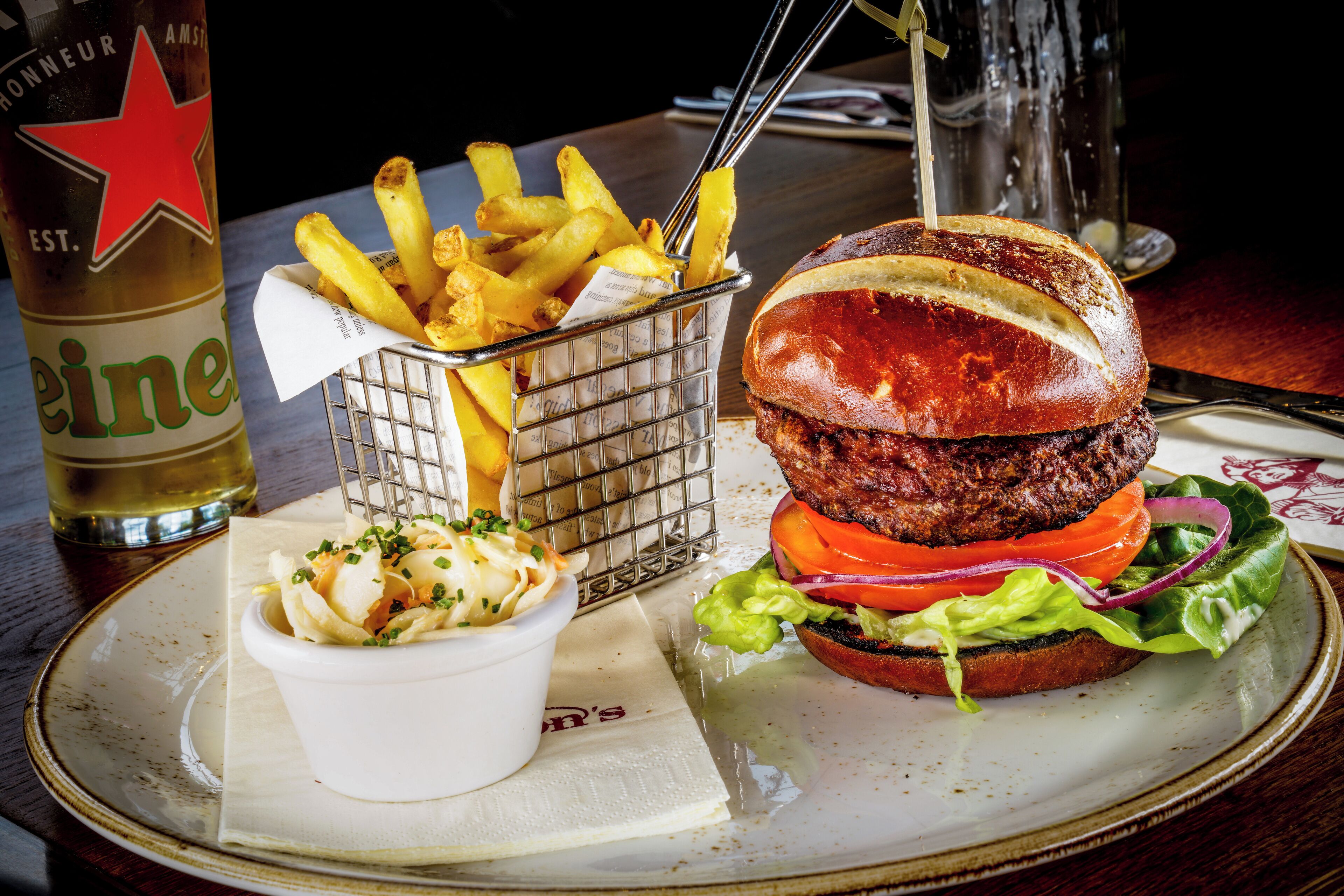 En tallerken med en burger, pommes frites og en drik.