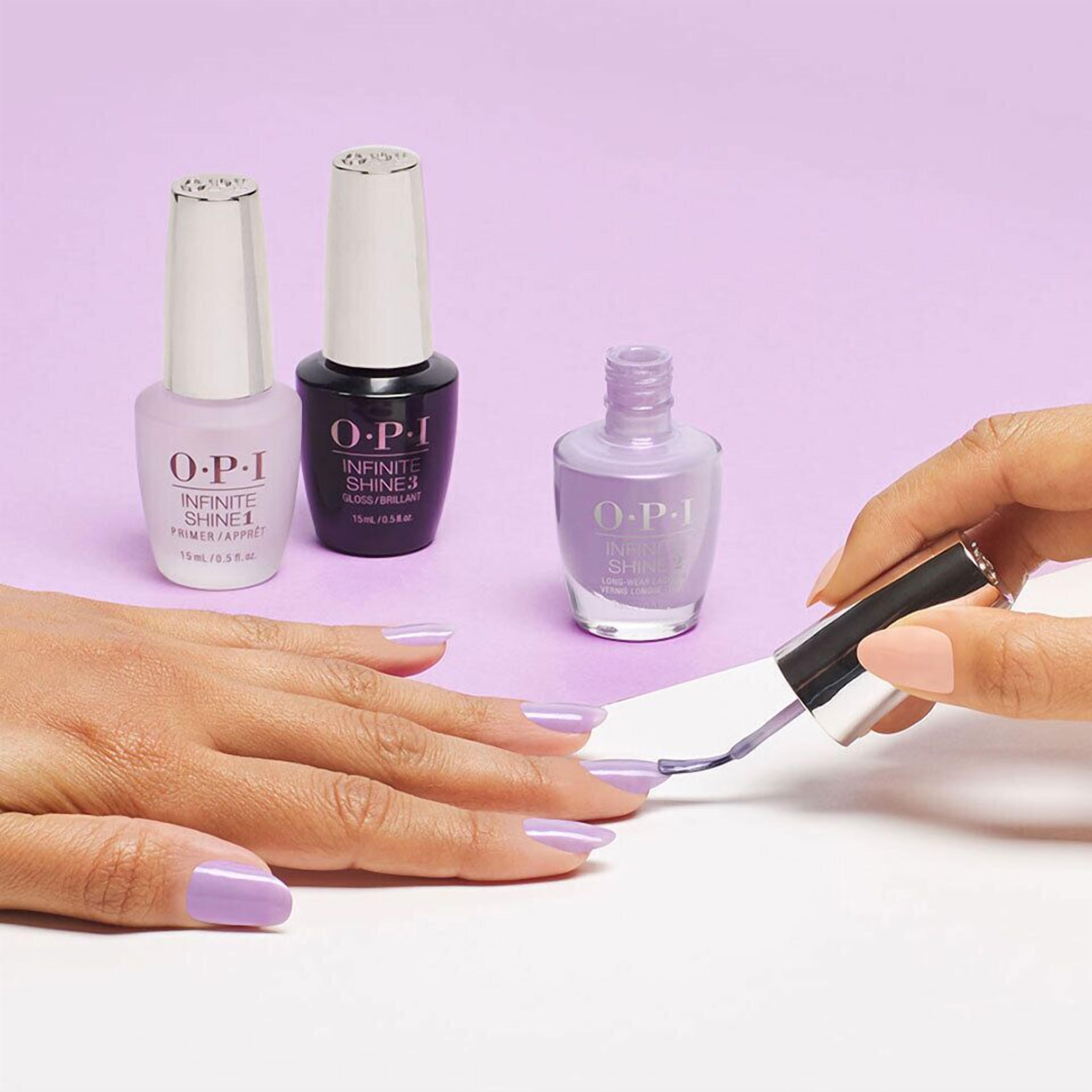 A hand applying OPI nail polish.