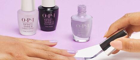 A hand applying OPI nail polish.