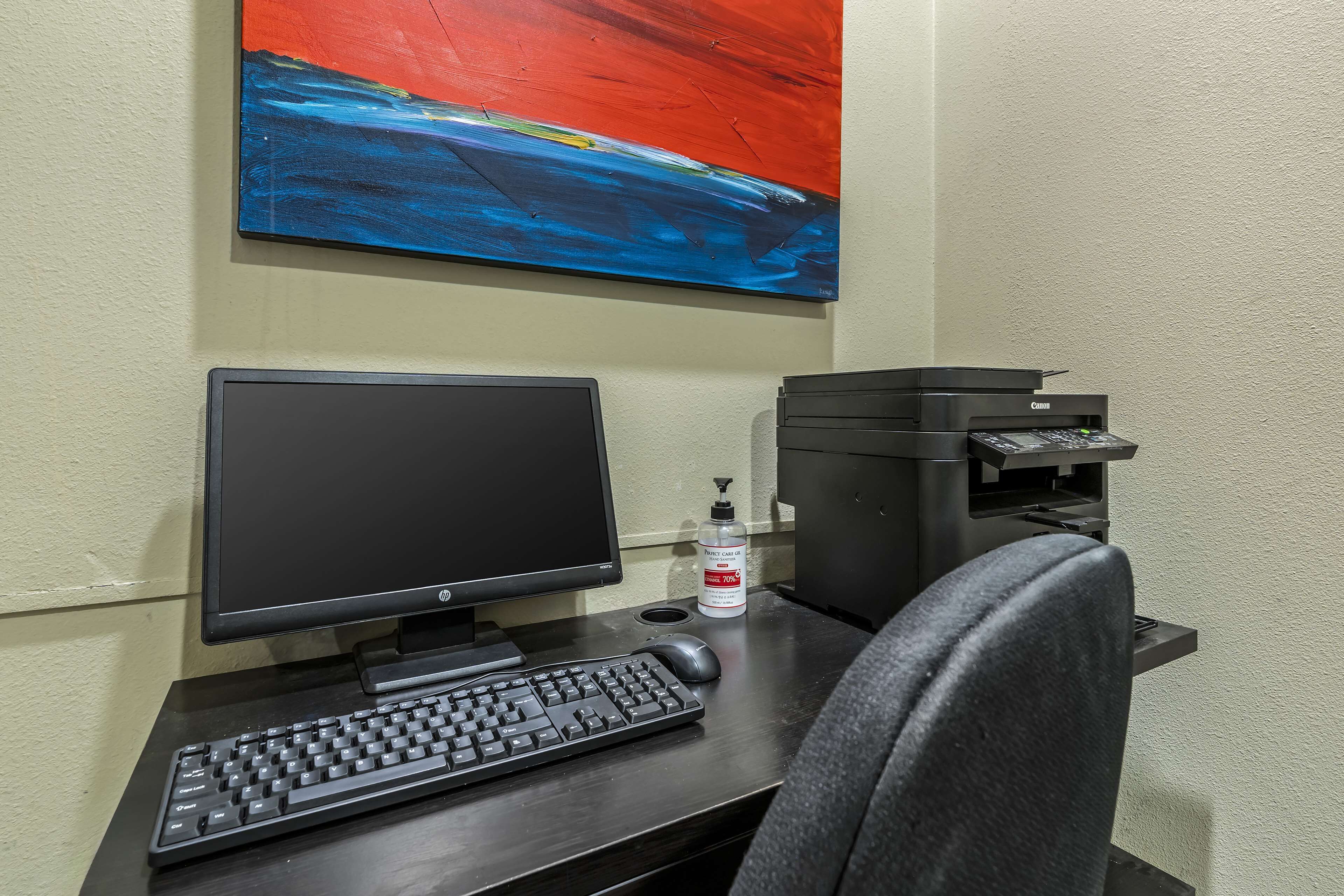 A desk with a computer, keyboard, mouse, and printer.