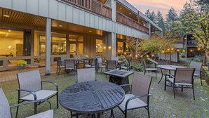 An outdoor patio with tables and chairs, a covered seating area, and a view of the surrounding trees and sky. - Mt Hood Oregon Resort, BW Premier Collection (Welches)