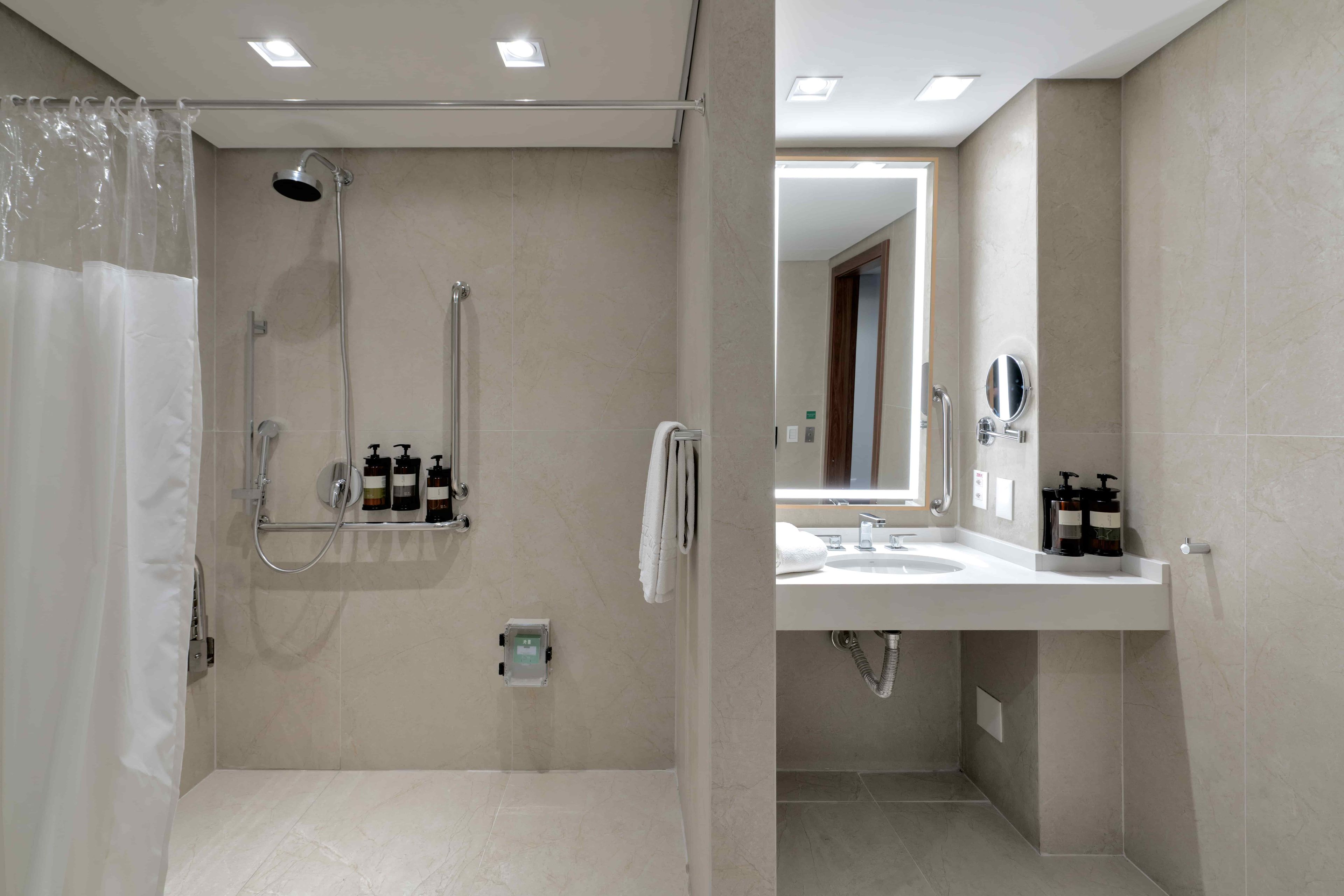 Ein modernes Badezimmer mit barrierefreier Dusche, einem Waschtisch und einem Spiegel.