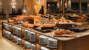 Montaje tipo bufé con diversos alimentos, platos y utensilios para servir.