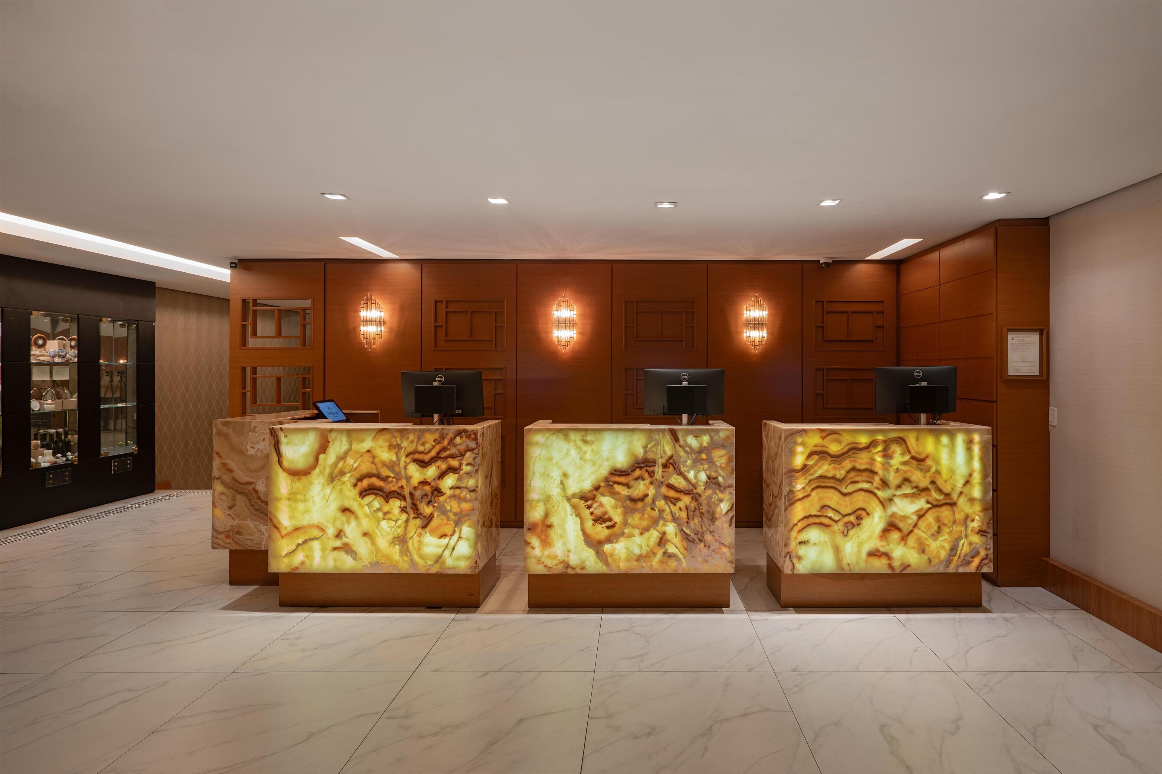 A reception area with marble-patterned counters, wall sconces, and a glass display case.