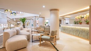 A spacious lobby with a reception desk, seating area, and a staircase. - Sol Sun Beach Apartamentos (Adeje)