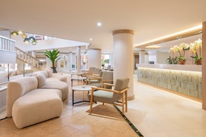 A spacious lobby with a reception desk, seating area, and a staircase. - Sol Sun Beach Apartamentos (Adeje)