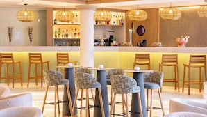 A bar area with wicker chairs, a bar counter, and hanging wicker light fixtures. - Sol Sun Beach Apartamentos (Adeje)
