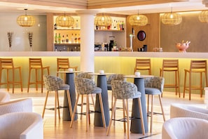 A bar area with wicker chairs, a bar counter, and hanging wicker light fixtures. - Sol Sun Beach Apartamentos (Adeje)