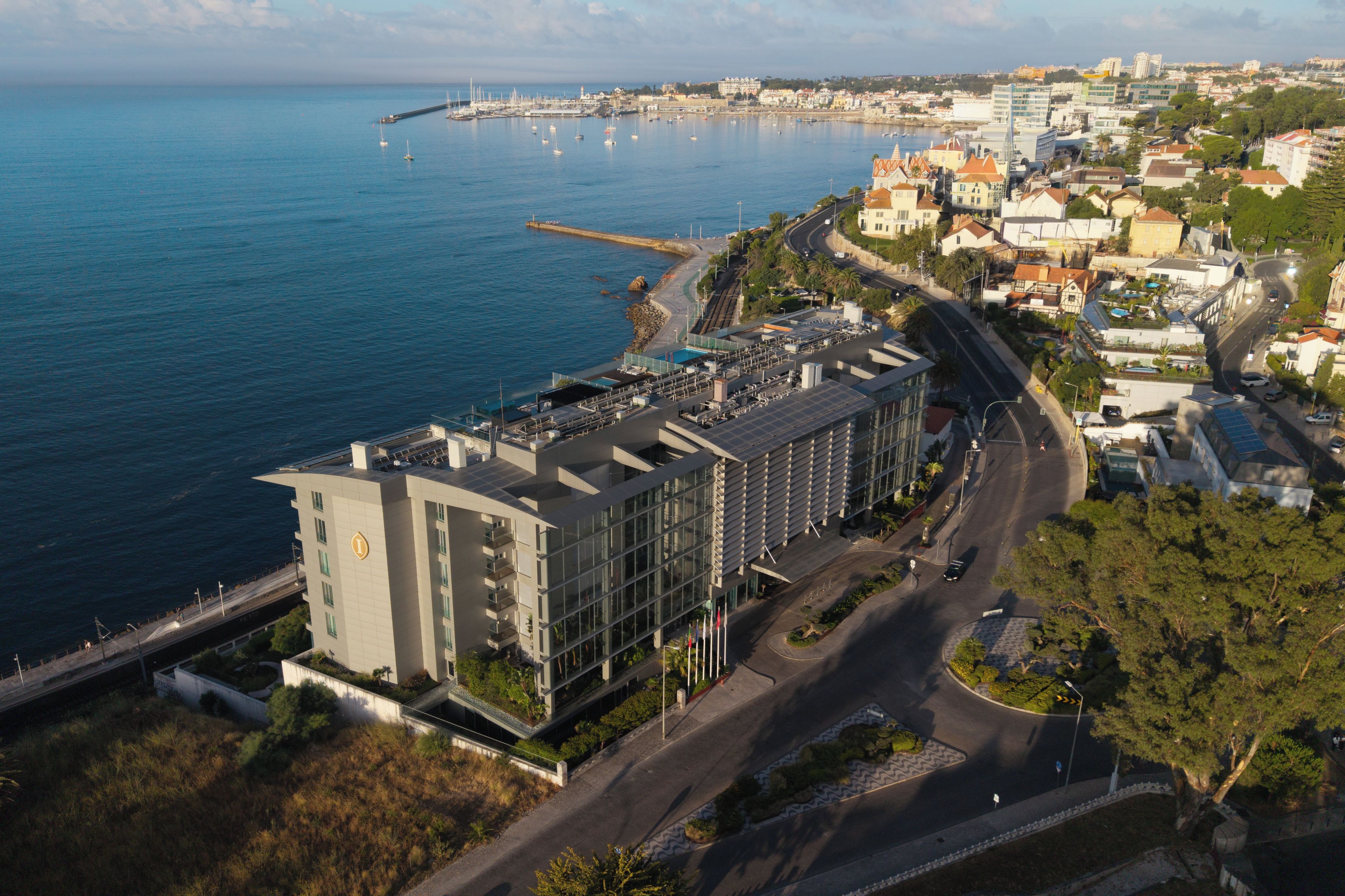 A modern building with a flat roof, located near a waterfront with a marina.