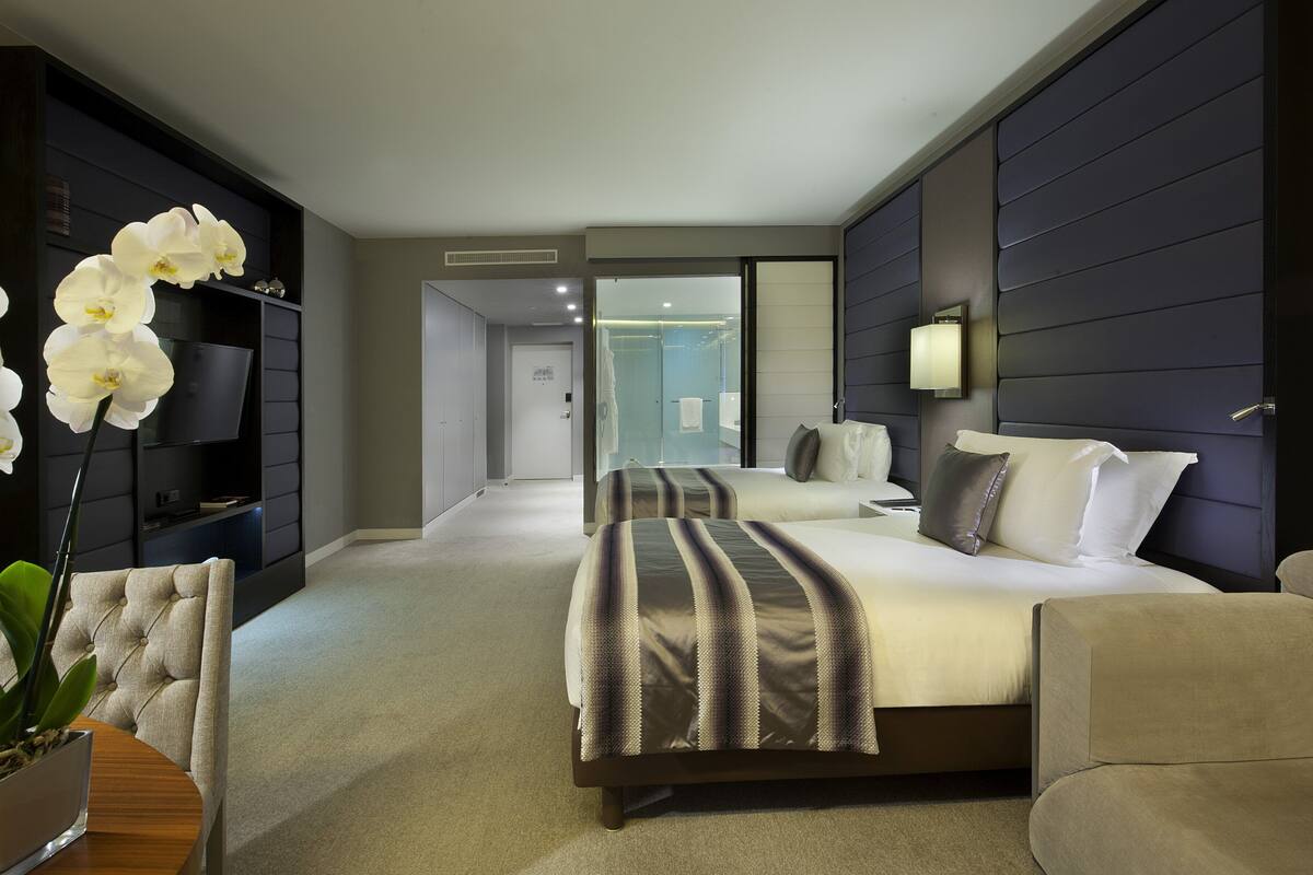 Ein modernes Hotelzimmer mit einem großen Bett, einer Sitzecke und einem Fernseher.