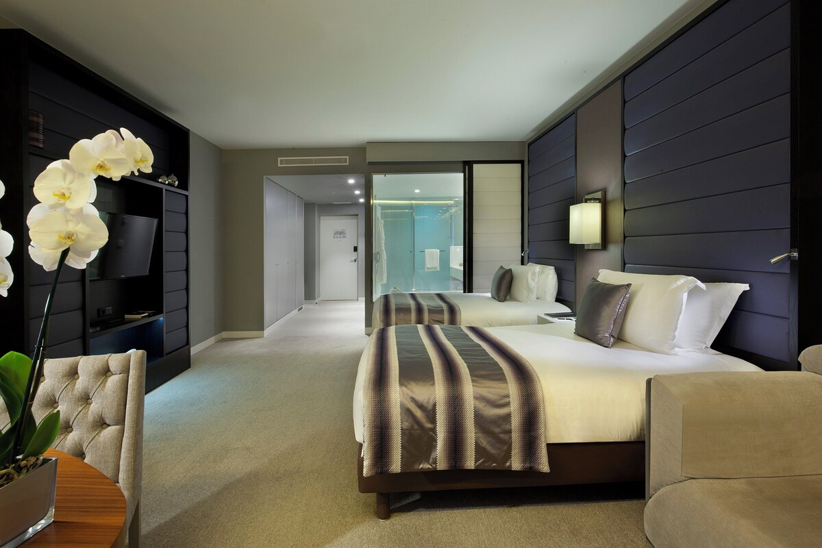 Een moderne hotelkamer met een groot bed, een zithoek en een televisie.