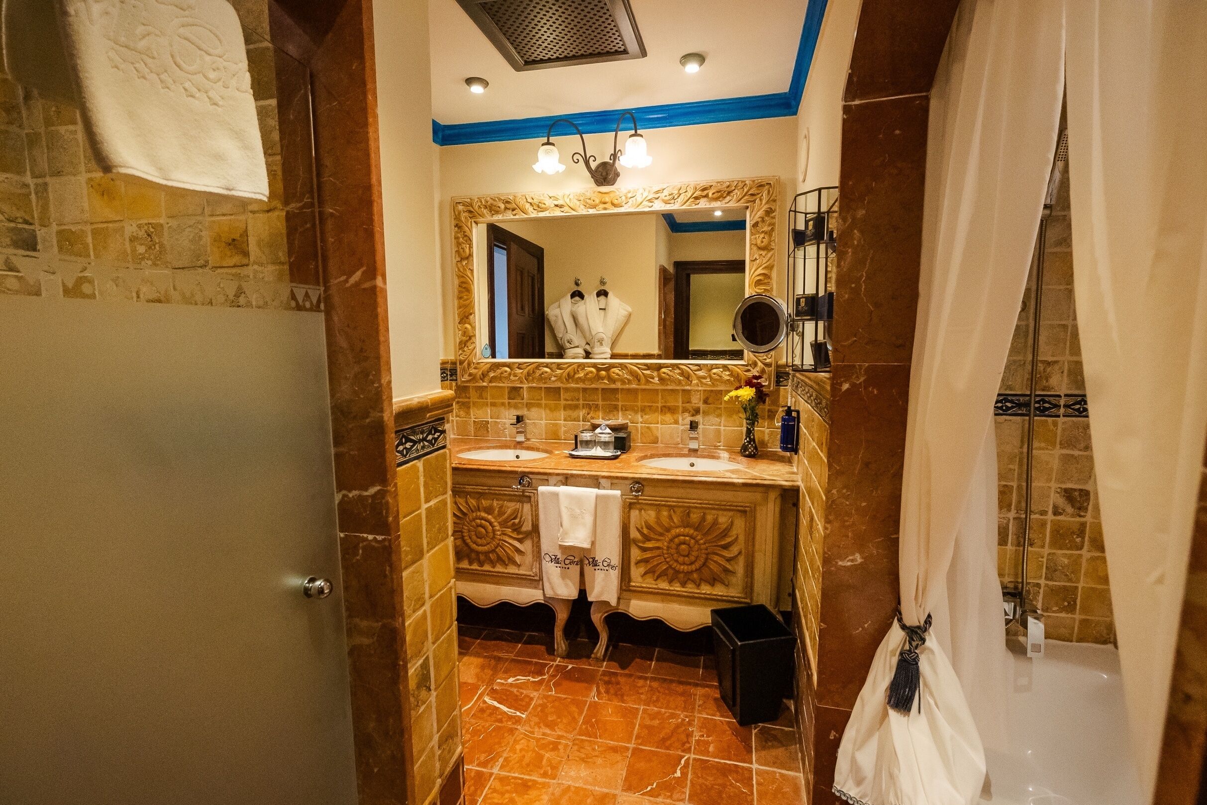 A bathroom with two sinks, a mirror, and a shower curtain.