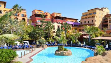 Een buitenzwembad, ligstoelen bij het zwembad