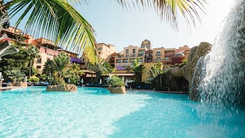 Una piscina al aire libre, sillones reclinables de piscina