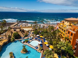 Un resort con una piscina amplia, acceso a la playa y vistas al océano.