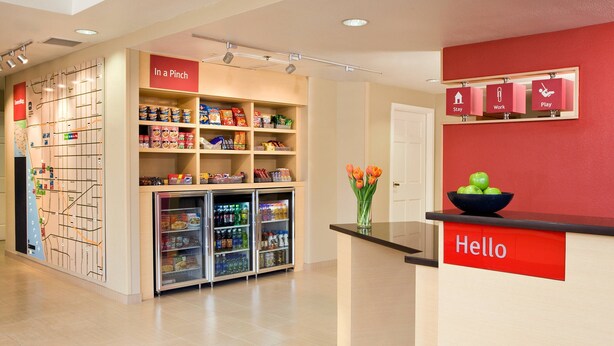 A reception area with a 'Hello' sign, a vending machine, and a 'In a Pinch' shelf with snacks.