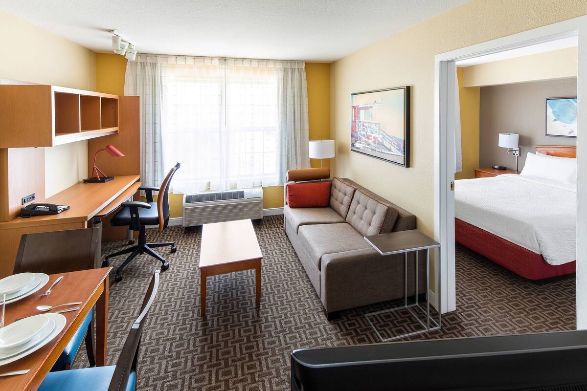 Une chambre d’hôtel équipée d’un bureau, d’une chaise, d’un canapé et d’un lit.