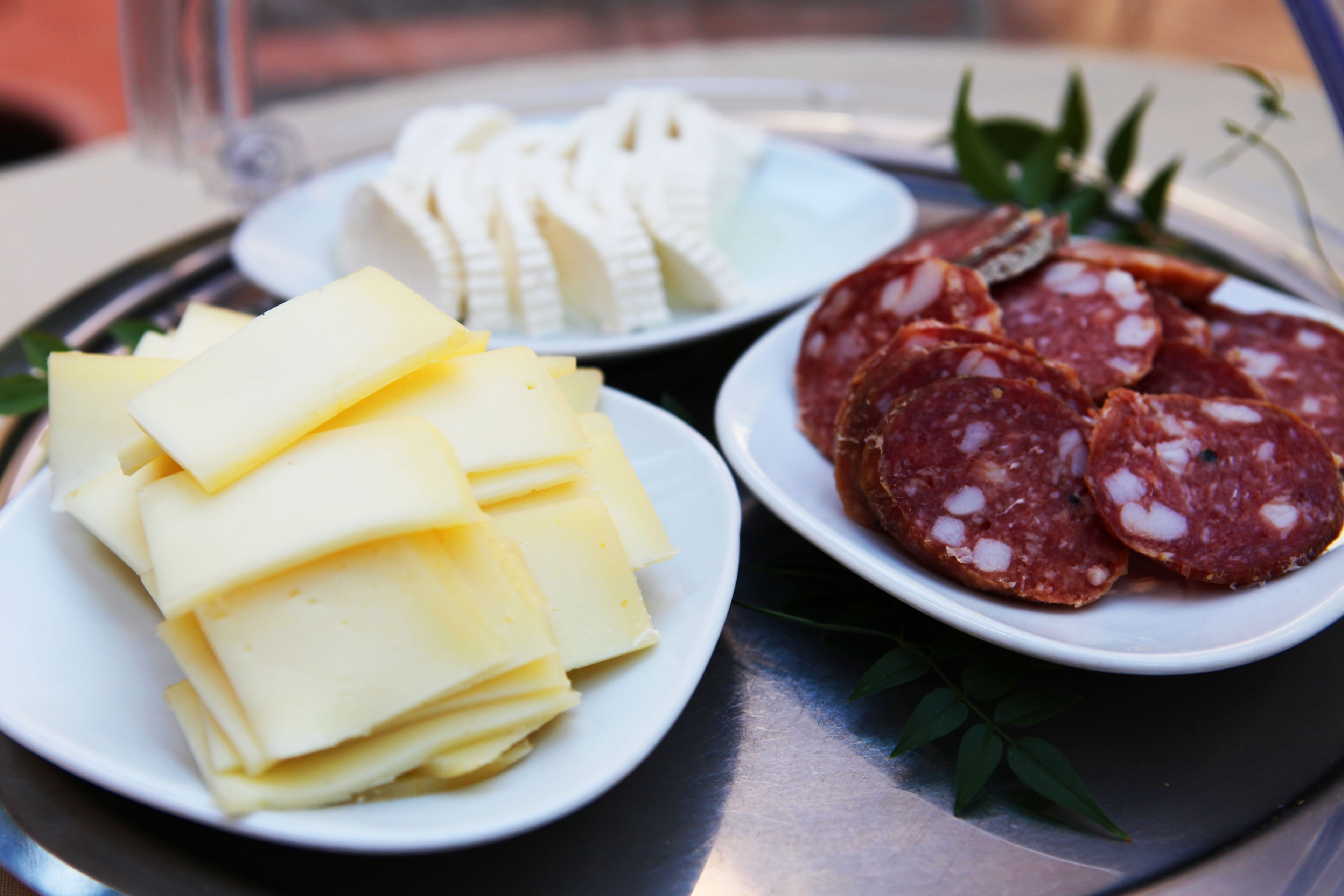 Un plateau avec des tranches de fromage et de salami.