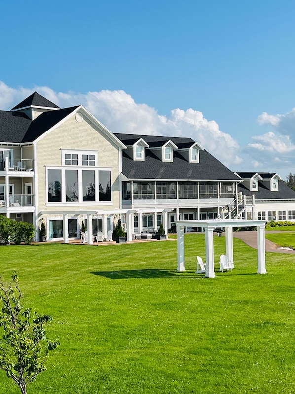 A large, multi-story building with a spacious lawn and outdoor seating area.