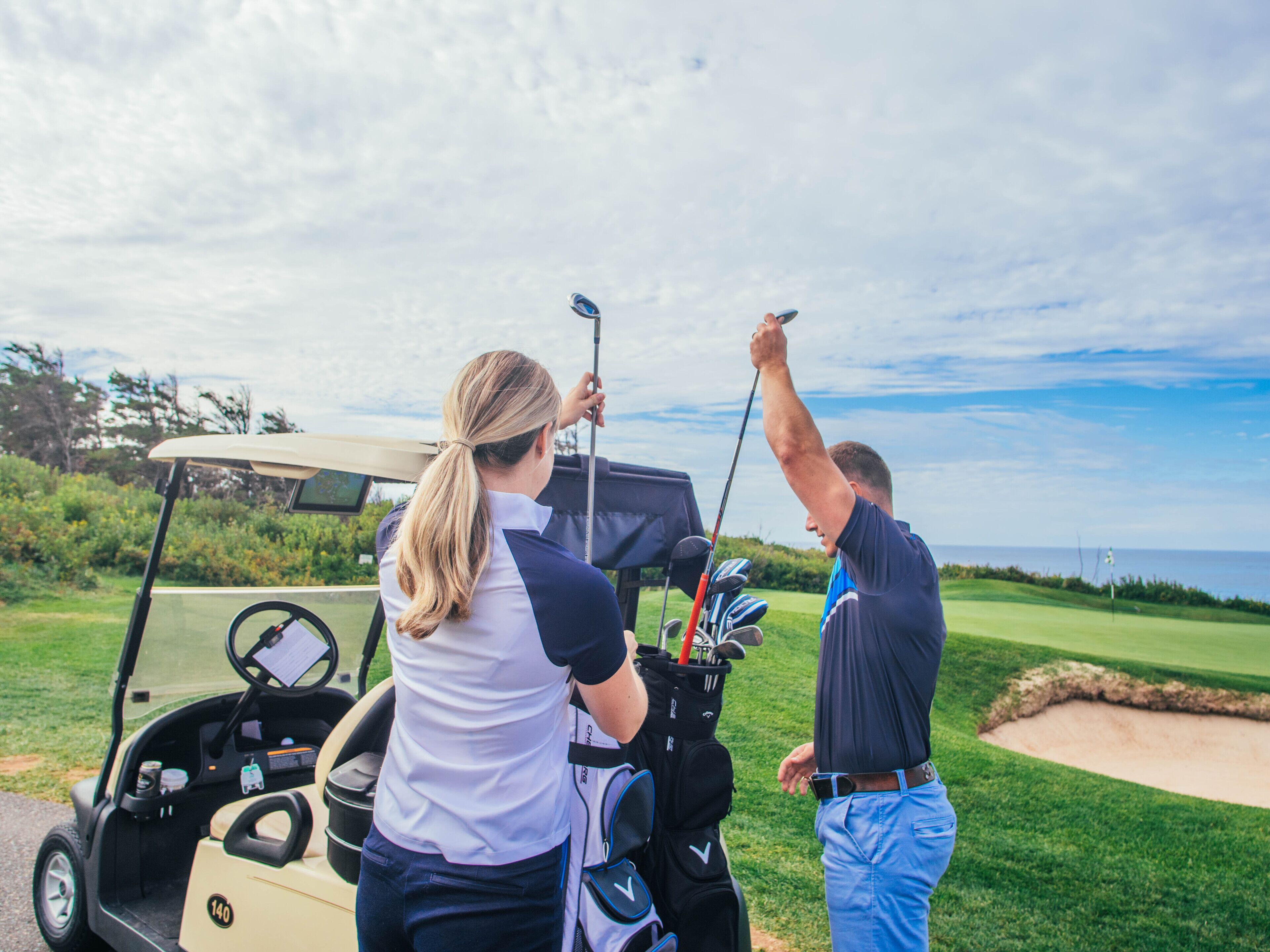 A golf cart with a driver and a bag of golf clubs.