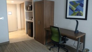 A hotel room with a wooden desk, a green office chair, a framed abstract painting, and a wardrobe. - Holiday Inn Express & Suites Indianapolis Northwest by IHG (Indianapolis)