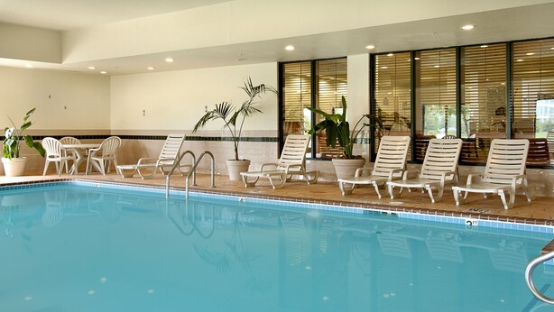 An indoor swimming pool with lounge chairs and potted plants. - Holiday Inn Express & Suites Indianapolis Northwest by IHG (Indianapolis)