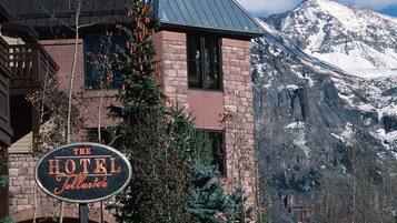 Un hotel con montañas al fondo, un cartel que dice 'The Hotel Jimmie' y un techo de metal.