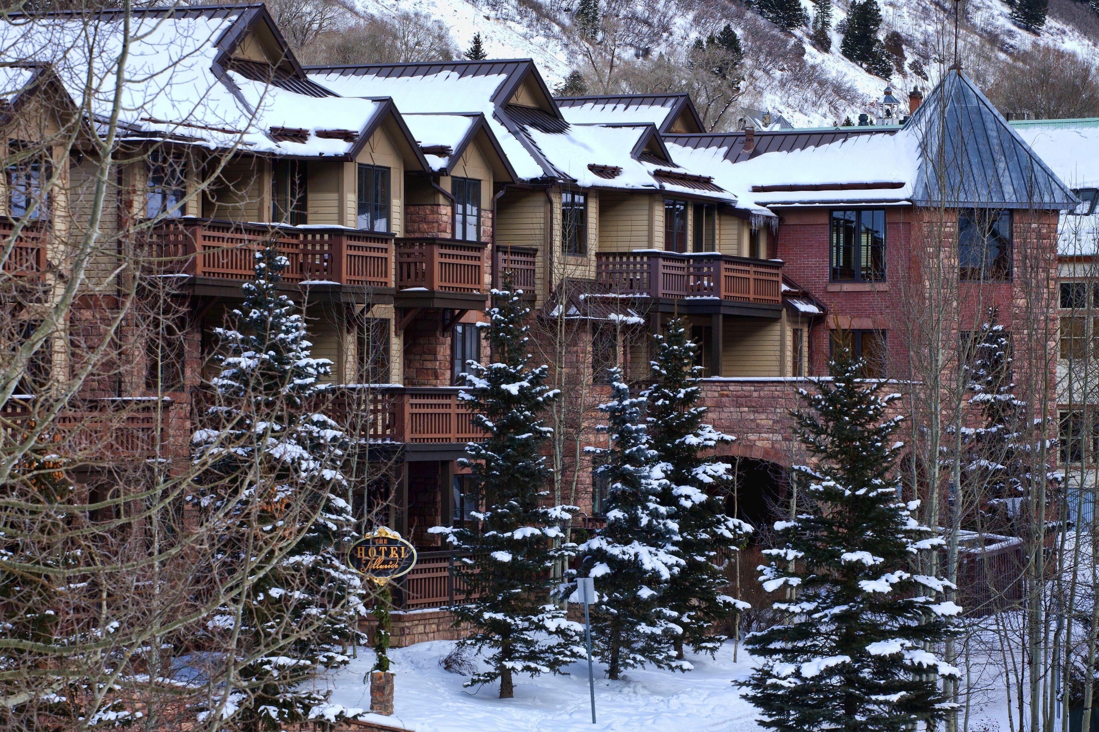 Un hotel de varios pisos con un estilo arquitectónico tradicional, que cuenta con balcones y un paisaje cubierto de nieve.