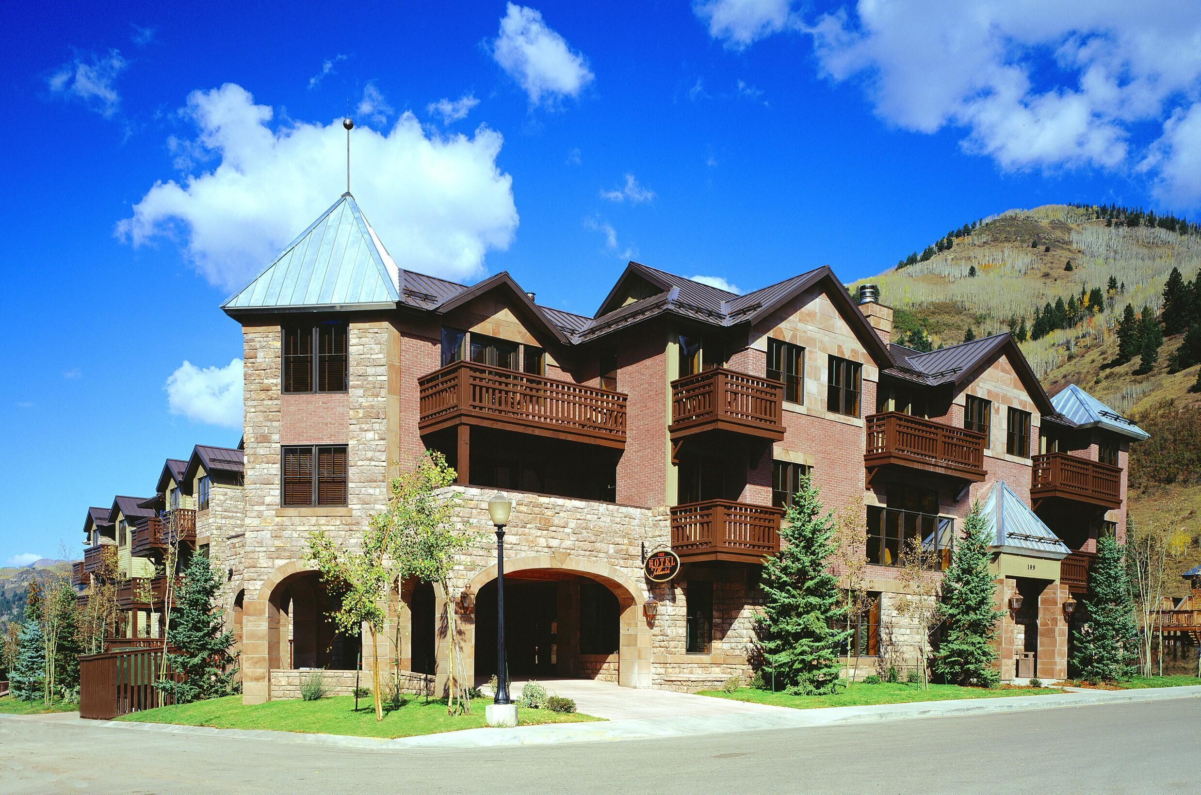 A multi-story hotel with a stone facade, multiple balconies, and a prominent tower-like structure.