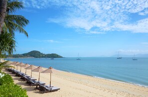 Plage, sable blanc, chaises longues, parasols