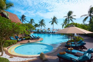 Una piscina al aire libre, sombrillas, sillones reclinables de piscina