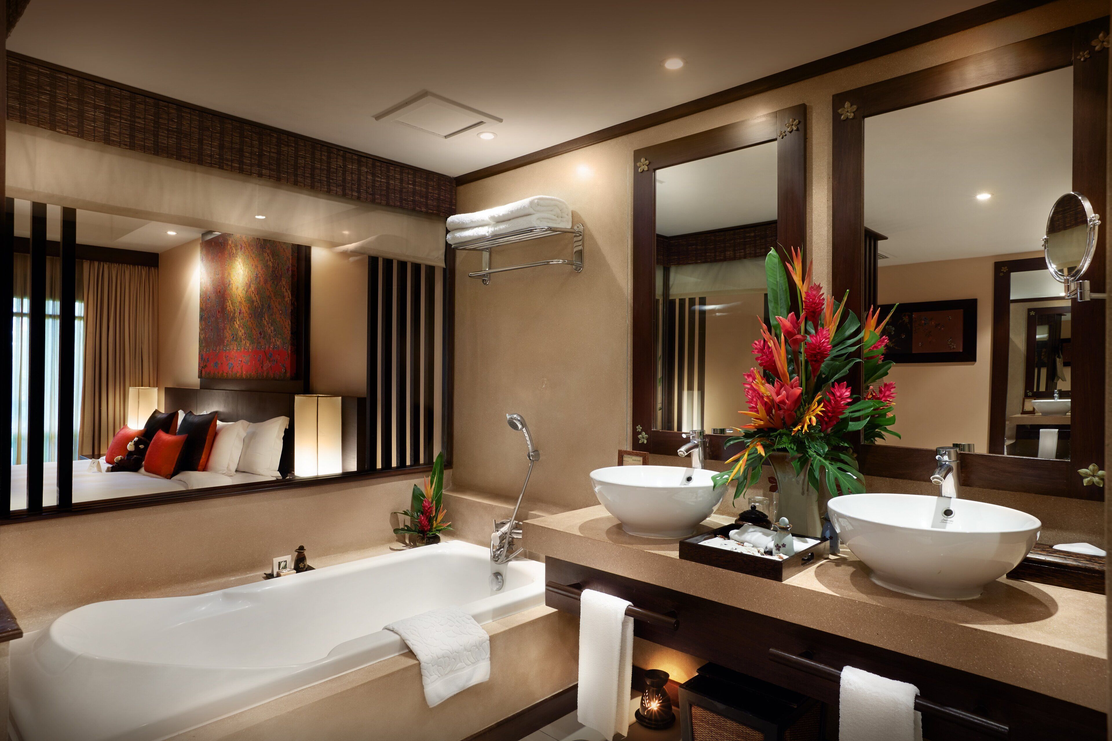 Une salle de bain moderne avec une grande baignoire, deux lavabos et un grand miroir.