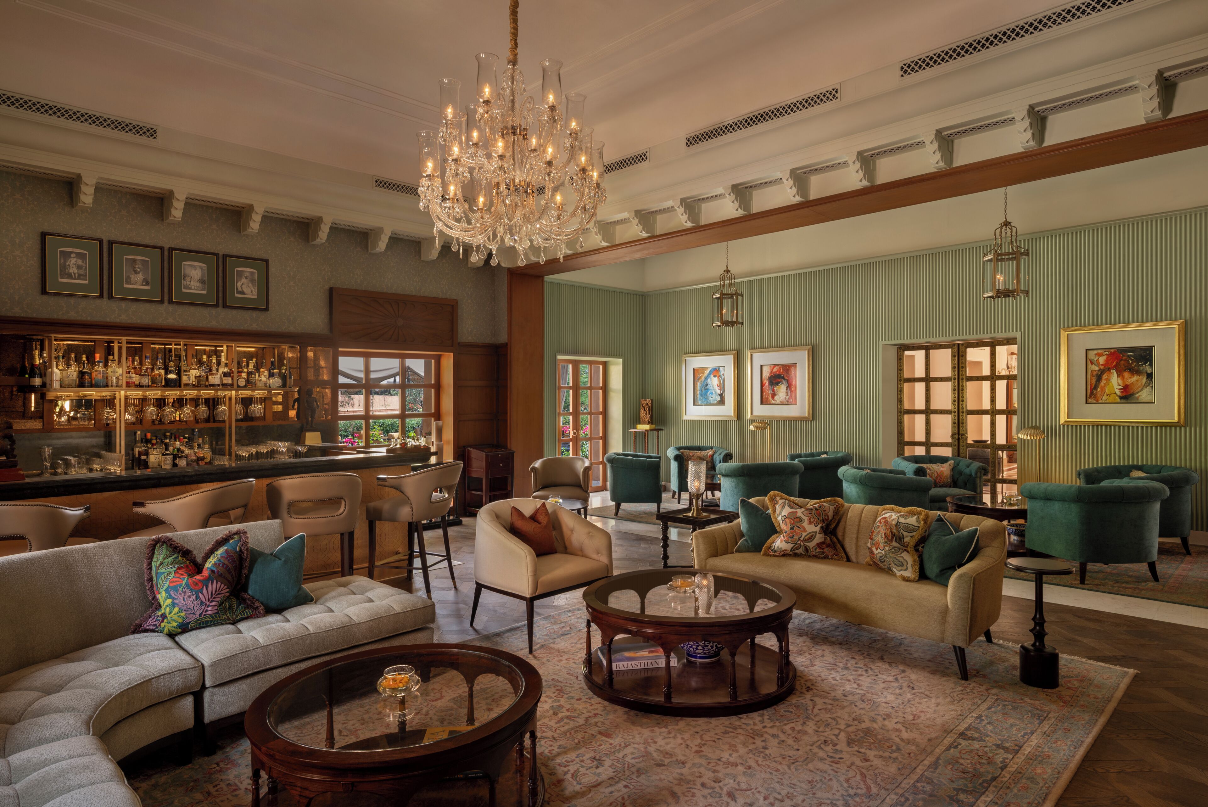 A spacious lounge with a bar, multiple seating areas, and a chandelier.