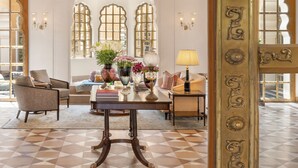 Un grande lampadario, decorazioni elaborate alle pareti e una stanza ben illuminata con pavimento a scacchi.