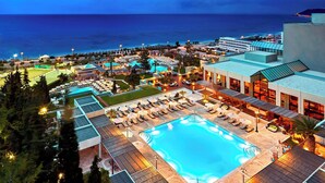 Un complex turístic amb piscina, gandules i vistes a l'oceà.