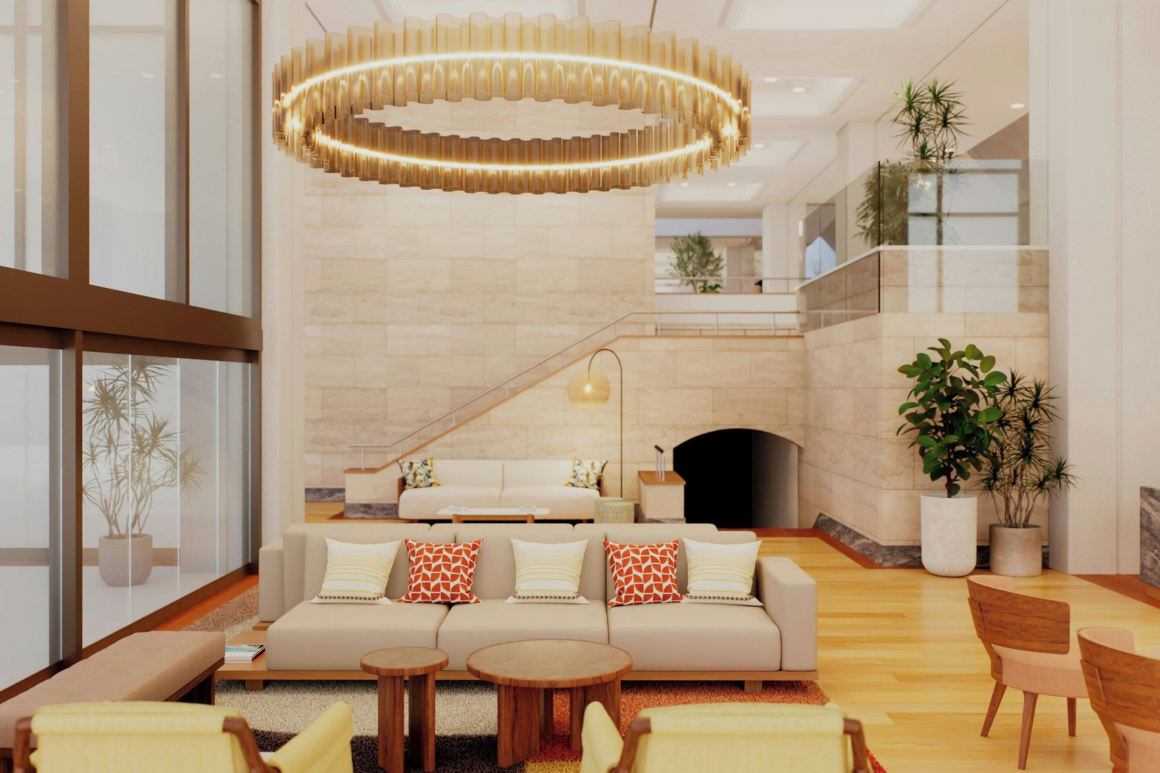 A modern interior with a sofa set, round tables, and a large chandelier.