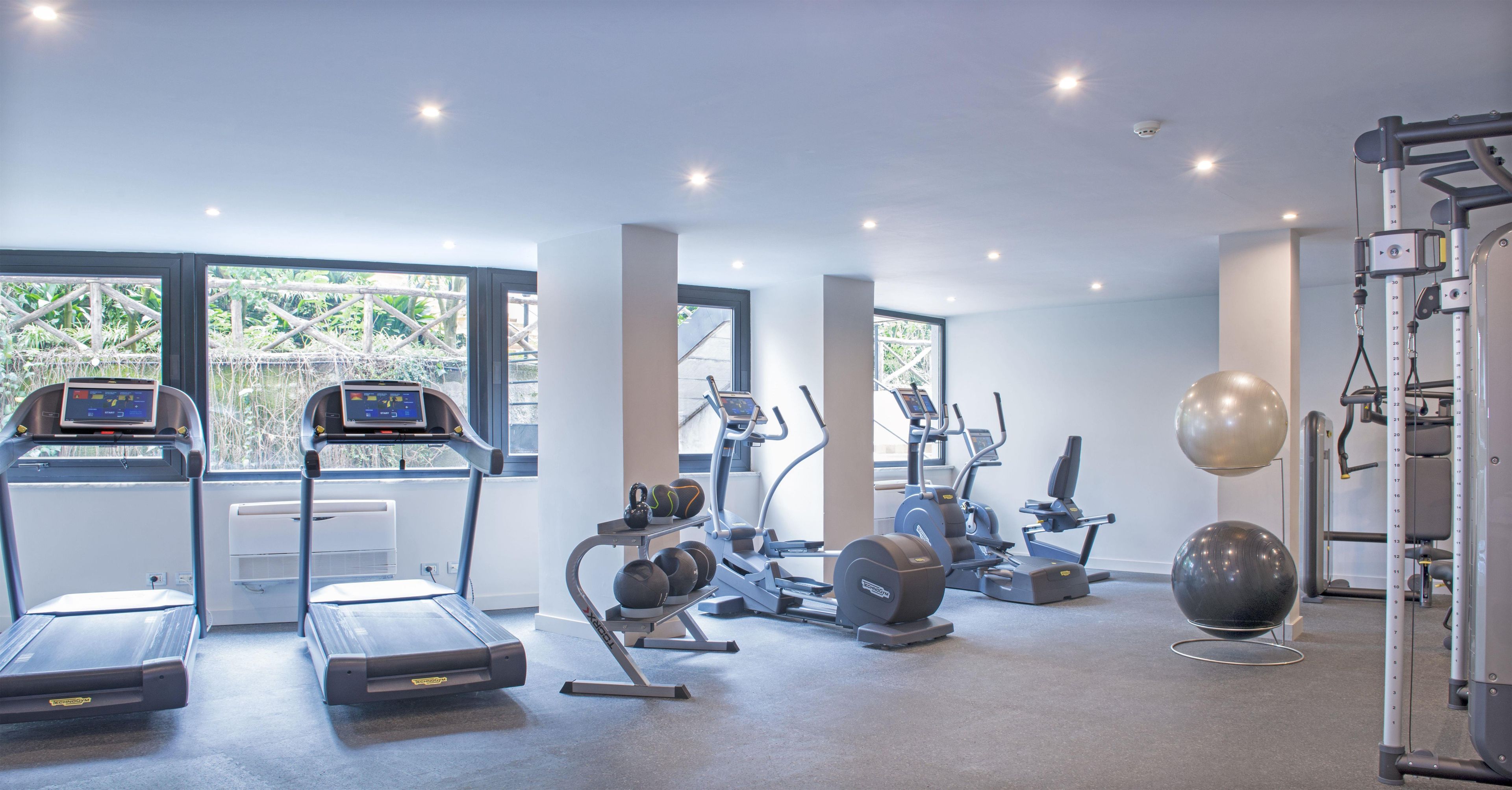 A gym with treadmills, elliptical machines, and free weights.