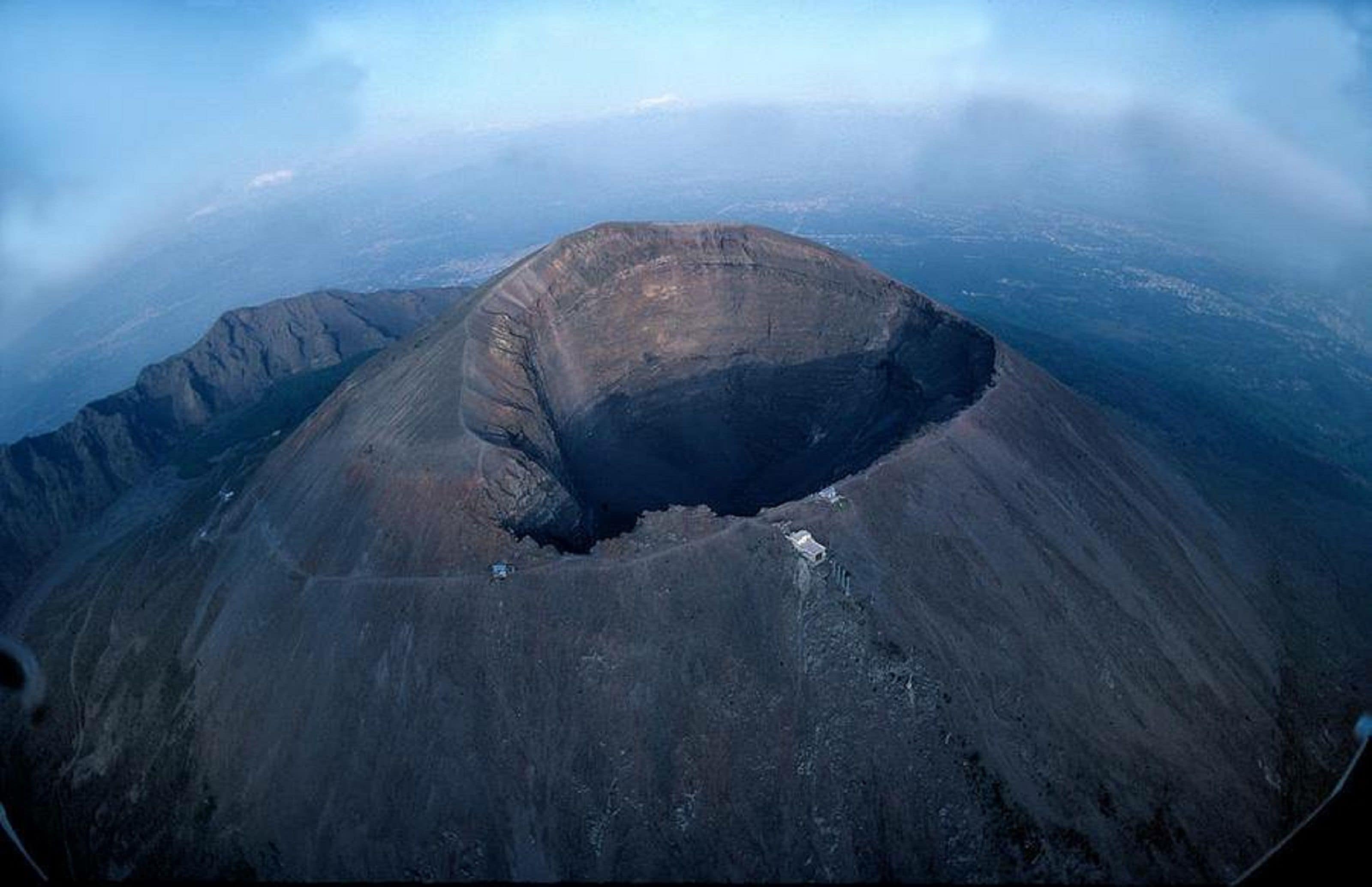 A large volcanic crater with a small building at its center.