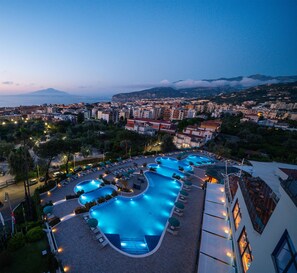 A resort with multiple swimming pools, a view of the city, and a mountainous backdrop. - Hilton Sorrento Palace (Sorrento)