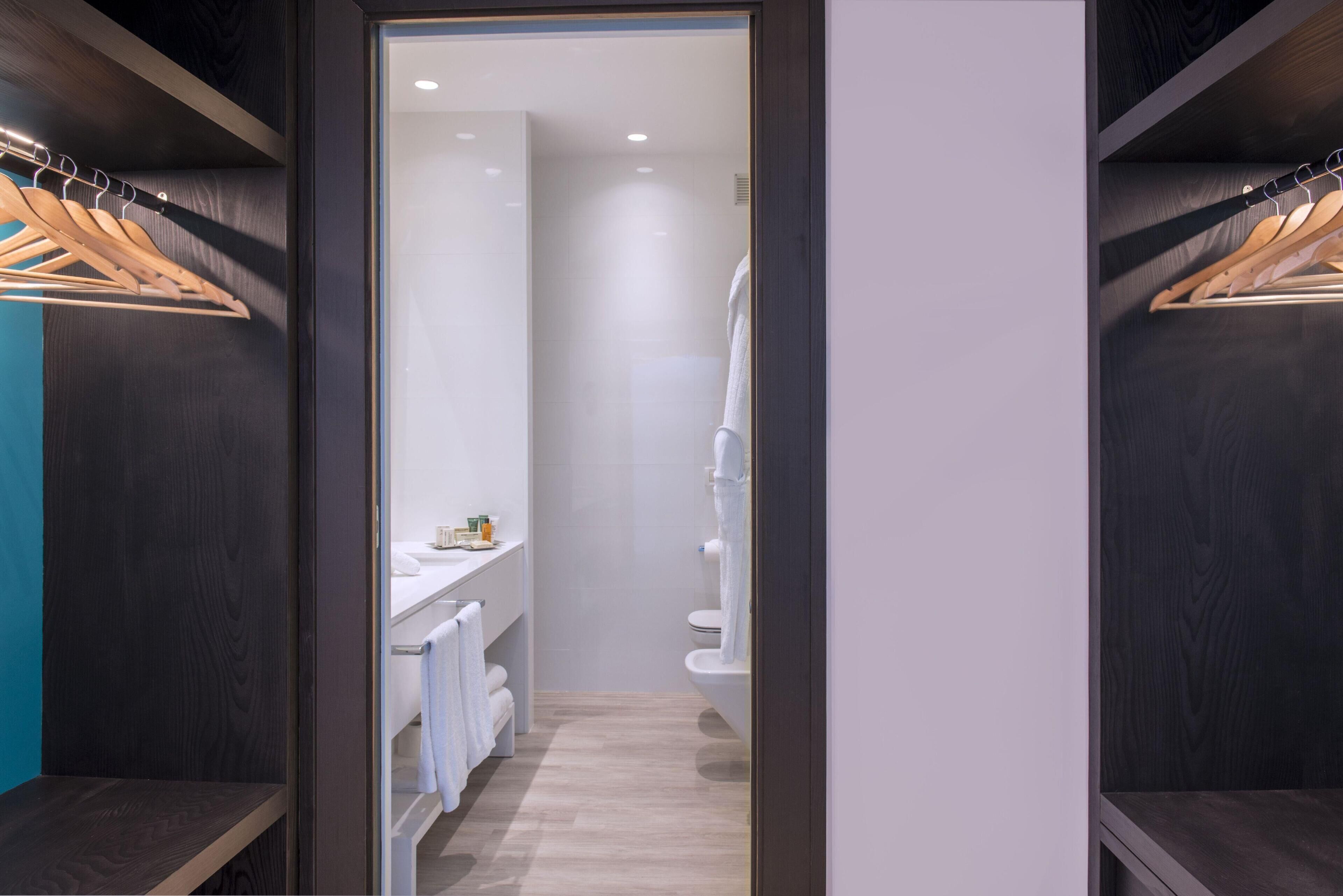 Un baño moderno con ducha, inodoro y toallero.