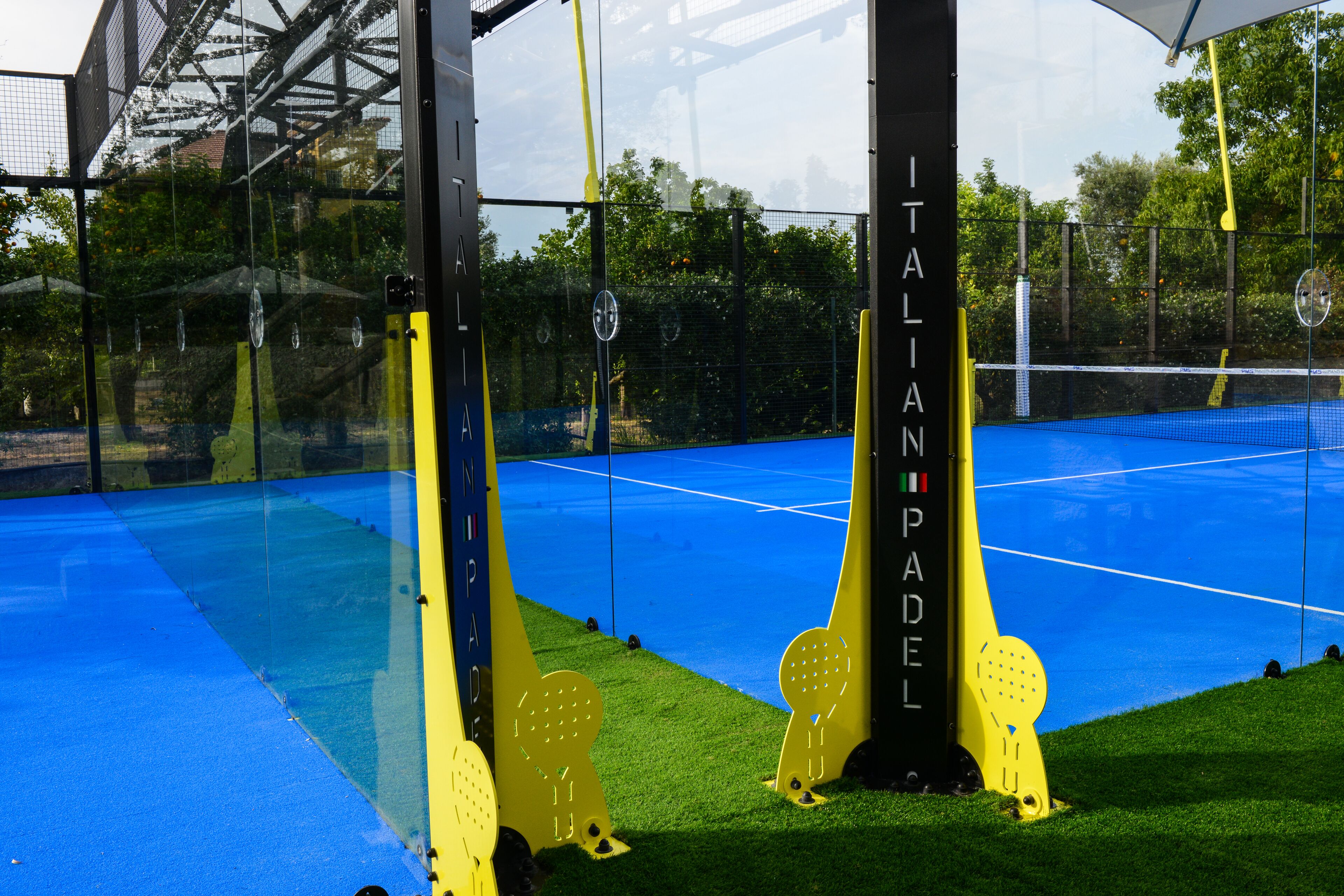 Una cancha de tenis con superficie azul y líneas delimitadoras amarillas.