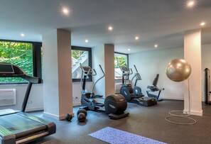 A home gym with treadmills, elliptical machines, and free weights.